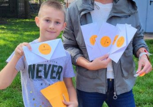 kobieta i chłopiec pokazują koperty z kropkami